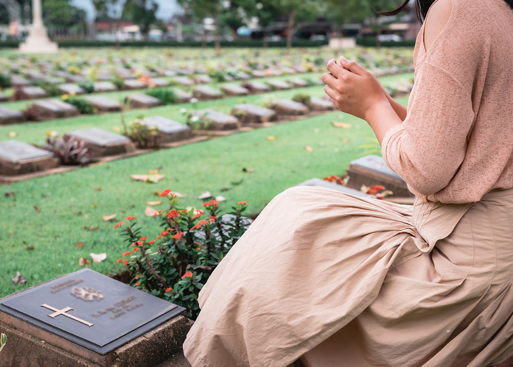 Close-up of a woman praying with hands clasped, seeking comfort after a wrongful death in Nevada.